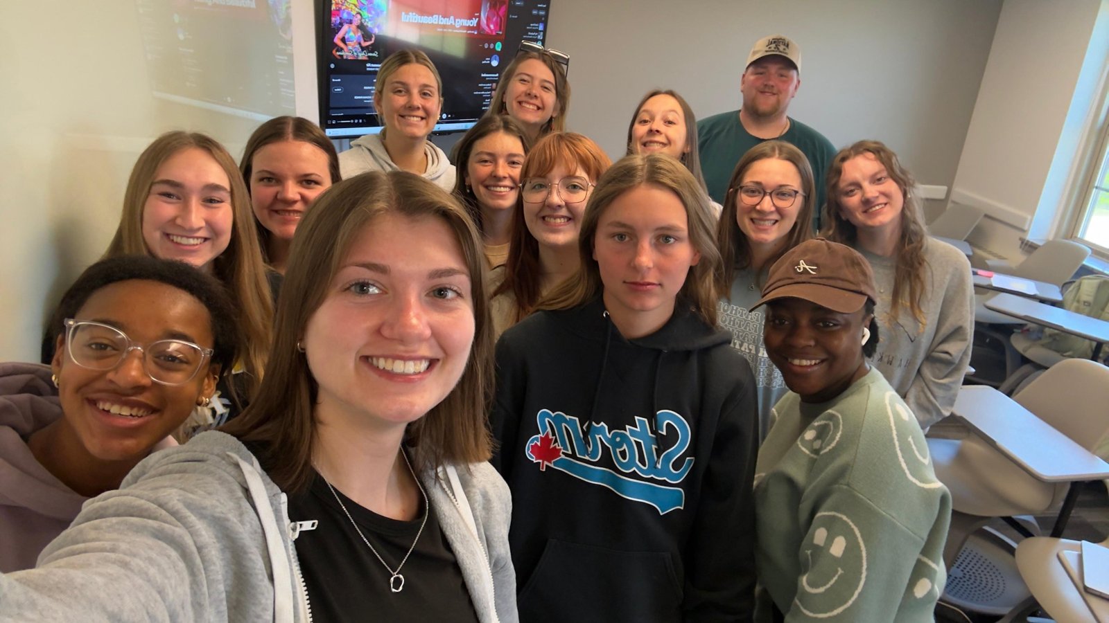 Students smiling together in a class selfie